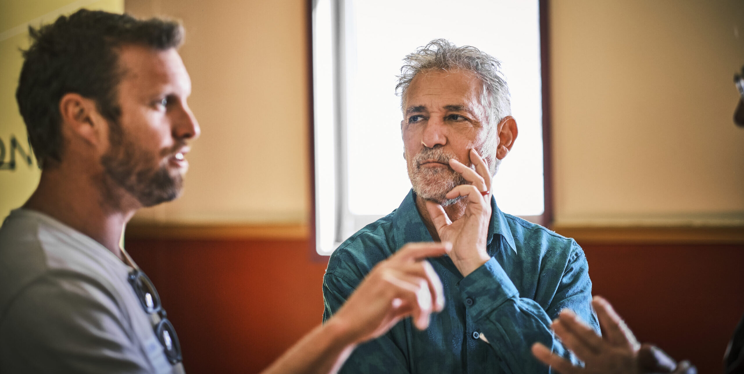 One man looks thoughtfully at another man as he talks