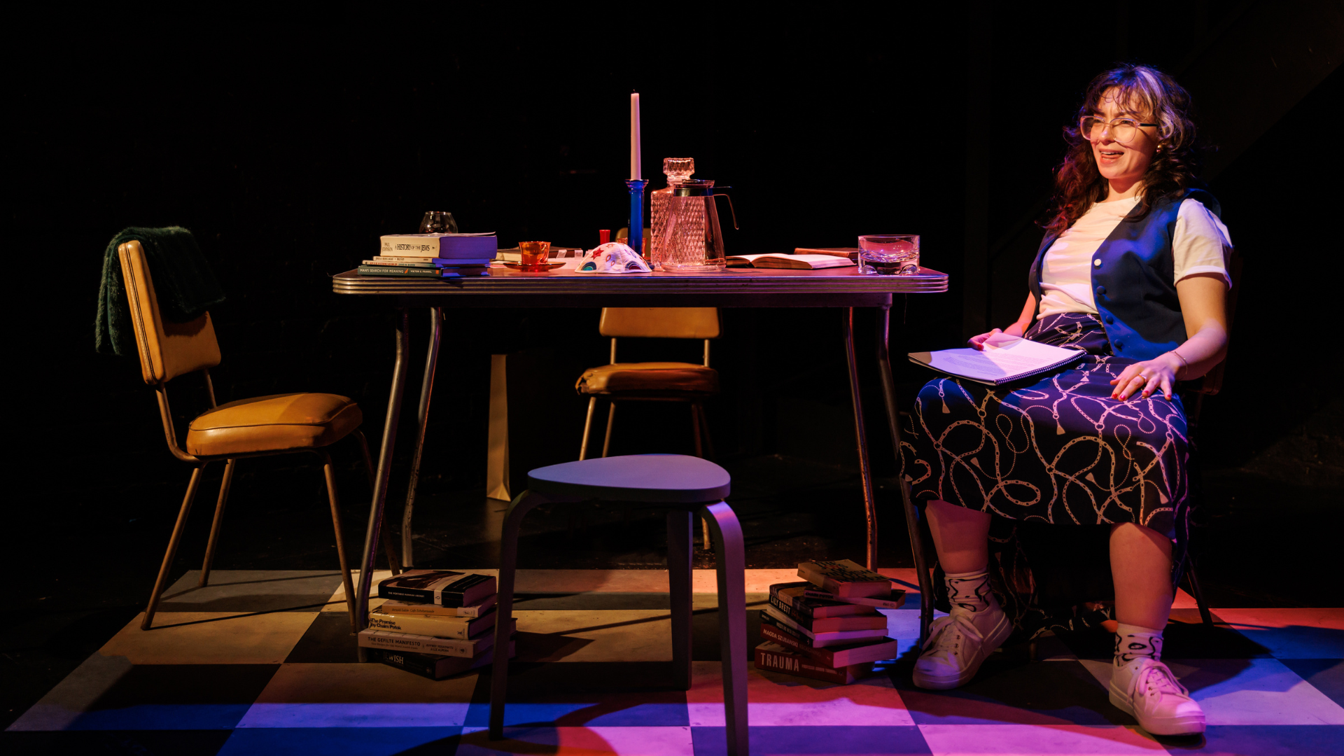 Woman sitting at a table and chairs surrounded by books