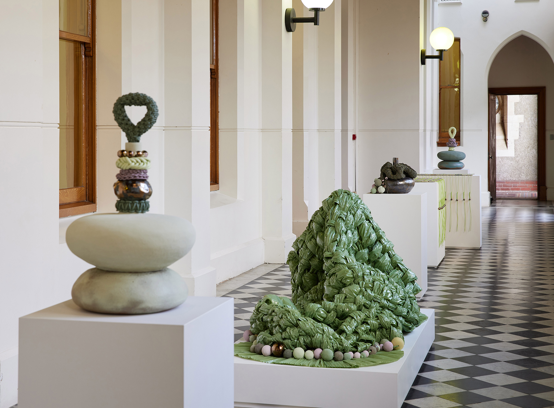 Sculptures in a long hall with checked flooring 